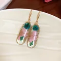 Eleganti orecchini ovali in resina con fiori rosa e blu e ganci dorati molto raffinati. - Oro-Rosa-Verde
