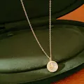 Primo piano di una collana con ciondolo a stella placcata oro 14k su velluto verde - Collana / Oro