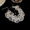 Close-up of elegant French style beaded pearl necklace with intricate floral patterns - Bracelet / Small / White