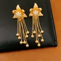 Macro view of 18k gold plated flower earrings with sparkling zircon centers and tassels - Flower Tassel Style / Gold
