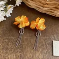 Detail of orange fabric flower earrings with sparkling zirconia and long tassels - Silver-Yellow
