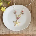 Detail shot of a ceramic starfish pendant necklace with shell and stone beads - White