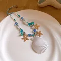 Détail du collier de perles en nacre avec coquillage et étoiles de mer bleues - Bleu