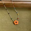 Detailed macro view of a summer dopamine flower beaded necklace with vibrant colorful beads - Necklace / Orange