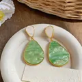 Dettaglio dei pendenti in resina verde effetto marmo con raffinata finitura dorata. - Stile Perno in Argento / Verde