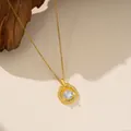Primer plano de un collar con colgante de circón dorado sobre fondo de madera natural. - Collar Redondo de Diamante Único (9117) / Dorado