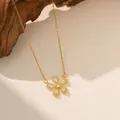Primer plano de un collar con colgante de flor dorada y piedras de circón sobre fondo de madera. - Collar de Flores con Diamante Blanco (9165) / Dorado
