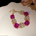 Detail eines Vintage-Goldarmbands mit lila quadratischen Steinen, Perlen und Kristallen. - Armband / Lila