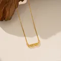 Primer plano detallado de un collar de barra de acero de titanio dorado con piedras de circón - Collar de Diamante Colgante Lineal (9177) / Dorado