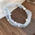 Detail of light blue mesh necklace with pearls and rhinestone magnetic clasp. - Blue