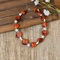 Detailed view of beach vacation necklace with orange beads and white starfish - Orange