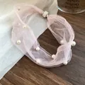 Close-up of pink mesh necklace with pearls and a sparkling magnetic rhinestone clasp. - Pink