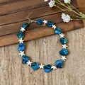 Close-up detail of blue and white starfish beads on a beach vacation style necklace - Blue