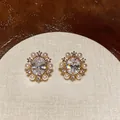 Detailed macro view of 14k gold-plated zircon and pearl vintage clip-on earrings - Oval Artificial Pearl Ear Clip (HE32180) / One Pair / Gold