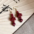 Detail of retro Chinese style wooden lotus drop earrings with red beads and gold hooks. - Red