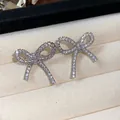 Close-up macro view of sparkling zircon encrusted bow-shaped clip-on earrings - Ear Cuff (Pair) / One Pair / Silver