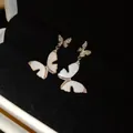 Close-up view of elegant butterfly drop earrings with white enamel and zirconia - Butterfly Enamel Style / Silver-White