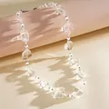 Vista macro dettagliata di perle in vetro trasparente e ciondoli a cuore su collana - Collana di Perline Cuore / Bianco