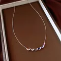 Close-up detail of silver-toned twisted clavicle chain with vibrant oval zirconia stones - Necklace (HN12460) / Silver