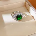 Close-up of elegant silver-toned ring with a large square emerald green gemstone. - Geometric Square Open Style / Green