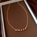 Detailed macro view of a gold twist collar necklace set with vibrant multi-colored gemstones - Necklace (HN12460) / Gold