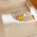 Detailed macro view of a silver-toned ring with a large yellow square-cut stone. - Geometric Square Open Style / Yellow