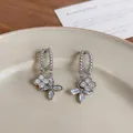 Close-up detail of French style floral stud earrings featuring sparkling cubic zirconia stones - Silver