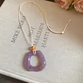 Lavender translucent resin ring pendant necklace with cream cord and orange bead detail. - Square / Purple