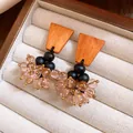 Gros plan de boucles d'oreilles ethniques vintage avec bois orange et perles roses - Style de Gland Ethnique Vintage / Café Noir Rose