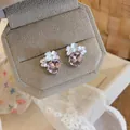 Primo piano di eleganti orecchini a lobo con fiori in cristallo rosa in un portagioie beige - Stile Argento / Perno in argento 925 / Rosa