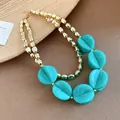 Close-up of double-layer necklace with turquoise acrylic discs and gold beads for resort style. - Necklace / Light Green
