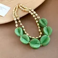Close-up detail of double-layer necklace with green acrylic beads and gold metallic accents - Necklace / Green