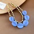 Detailed view of luxury double-layered necklace with blue acrylic beads and gold finish - Necklace / Blue