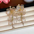 Detailansicht der Vintage-Ohrringe mit transparenten Acrylblüten und Kristalldetails - Vintage Blumen (HE28340) / Gold-Weiß