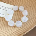 Elegant white acrylic swirl beaded bracelet featuring gold spacer beads for a resort look - Bracelet / White