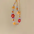 Close-up of colorful handmade beaded bracelet with floral crystal patterns and gold clasp. - Bracelet / Gold-Multicolor