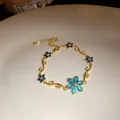 Gros plan d'un bracelet plaqué or 18k avec fleurs en zircon bleu et design vintage - Or-Bleu
