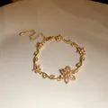 Détail d'un bracelet plaqué or 18 carats avec d'élégantes fleurs en zircon rose - Or-Rose