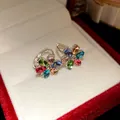 Detailed view of elegant flower earrings featuring colorful oval gemstones in a silver setting - Colorful