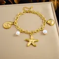 Détail d'un bracelet en acier doré avec des breloques en forme d'étoile de mer et de perles. - B2202 Bracelet