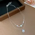 Close-up of double-layered necklace with star zircon pendant and pearls - Silver-Pearl