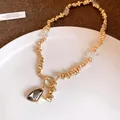 Detail of gold irregular bead necklace with a dark grey crystal triangle pendant - Rhinestone Irregular Triangle Necklace / Gold