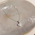 Detailansicht einer silbernen Herz-Halskette mit funkelnden Zirkonia-Steinen. - Halskette / Silber