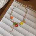 Vista dettagliata di un bracciale di perline colorate con ciondoli a fiore in smalto - Collana / Oro-Multicolore