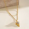 Close-up view of golden stainless steel double layer necklace with bicolor bow pendant detail - Necklace / Gold