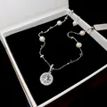 Detailed view of an elegant silver necklace featuring pearls and a sparkling star pendant. - Silver-Pink