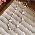 Detailweergave van de handgemaakte kralenketting met roomwitte zeesterhangers - Wit