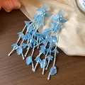 Detailansicht eleganter blauer Glasblumen-Quastenohrringe mit langen Perlensträngen. - Blau