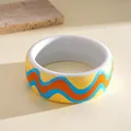 Detailed view of a thick colorful resin bangle with vibrant blue and orange wave designs - White Yellow Wave