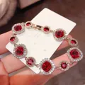 Luxurious red zircon flower bracelet with gold plating shown on display card holder - 31# Bracelet